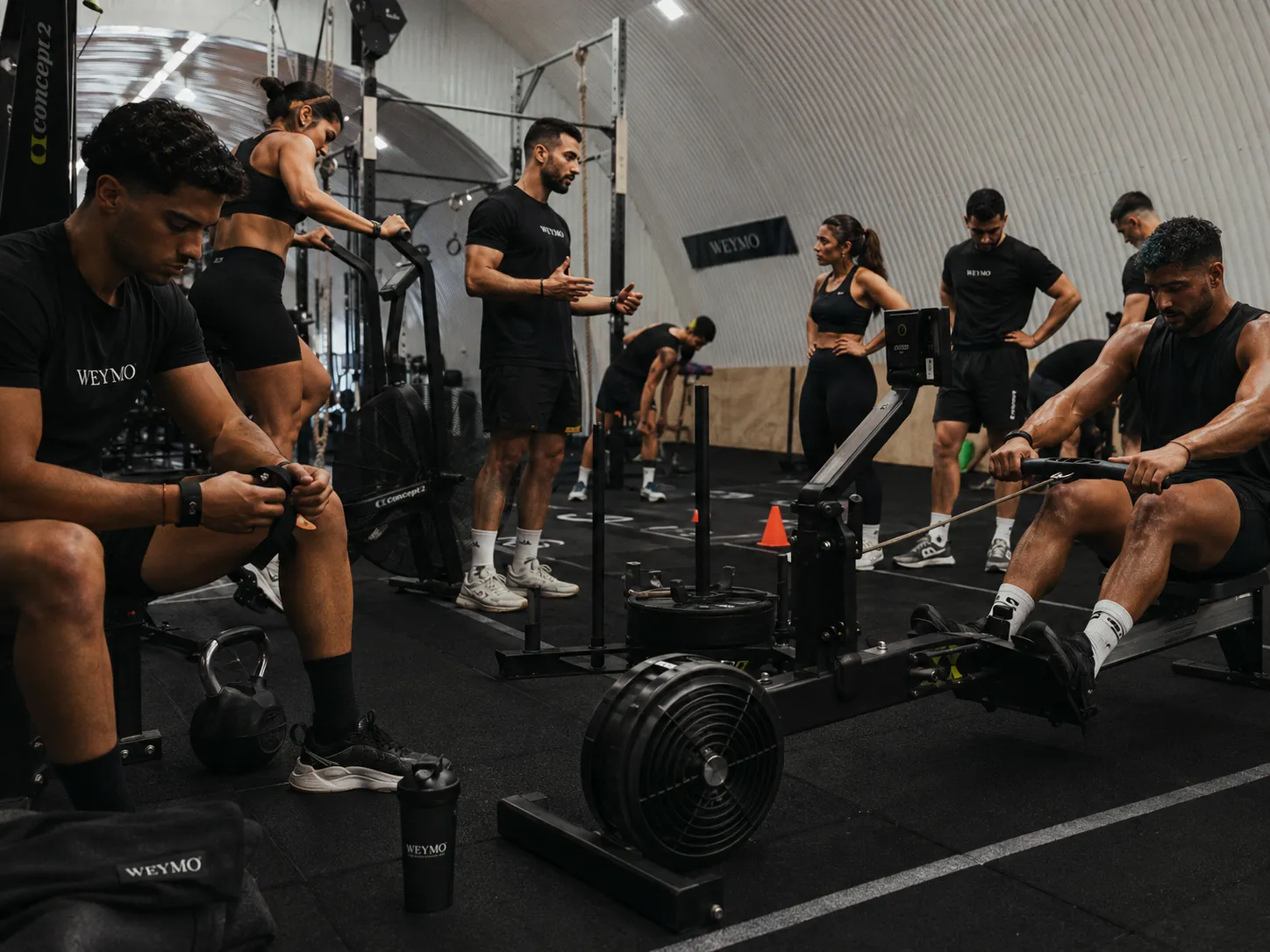 Séance collective dans une salle de sport aux couleurs Weymo.
